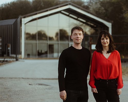 Orsolya Mátyus and Ian Chaplin in front of the electrical car service building in Solymár in Hungary